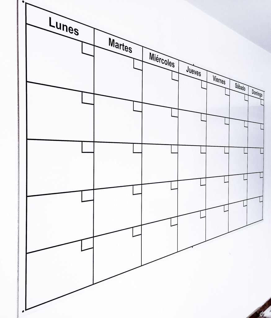 Tablero acrílico personalizado instalado en una oficina en Bogotá. El tablero tiene los días de la semana en forma de calendario para programar actividades.